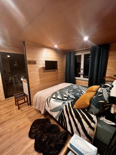 MazionChalet Ecolodge Mazion的一间卧室配有一张床和一台电视
