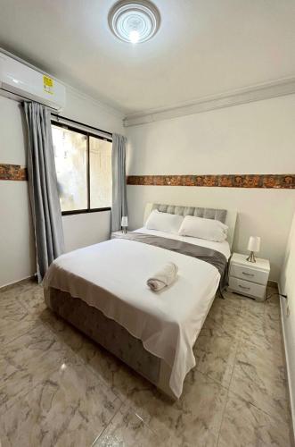 卡塔赫纳Apartamento Vacacional Cartagena Colombia的一间卧室设有一张大床和一个窗户。