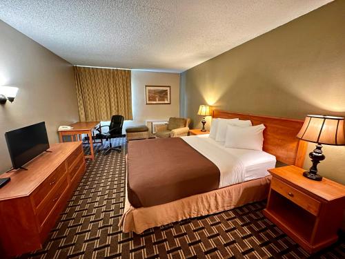 刘易斯顿FairBridge Inn & Suites - Lewiston的配有一张床和一张书桌的酒店客房