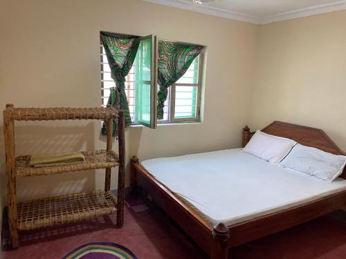 帕杰Afrobukuu house的一间小卧室,配有床和窗户