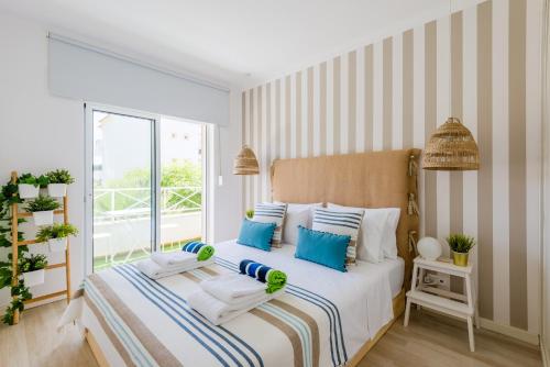 阿尔布费拉Alfamar Apartment at Praia da Falesia的一间卧室配有一张带蓝色和白色枕头的床