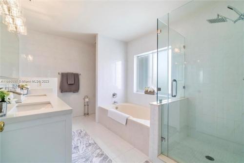迈阿密Kendall Vacation Luxury Home的一间带玻璃淋浴和水槽的浴室