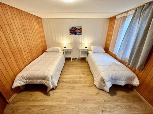 劳特布龙嫩Staubbach View - Traditional Chalet Apartment的配有两张桌子和一扇窗户的客房内的两张床