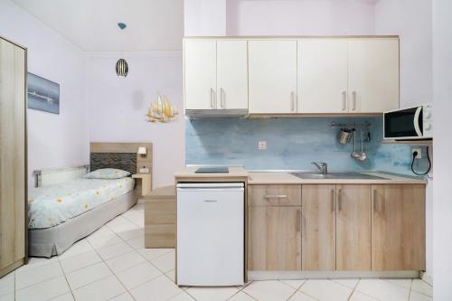 斯卡拉伯塔麦斯Endless Blue Sea Resort的一个带水槽的厨房和一张位于客房内的床