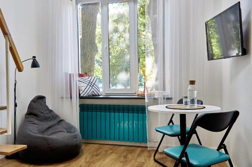 白采尔科维Затишні дворівневі смарт апартаменти的客房设有桌椅和窗户。