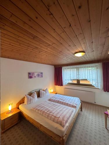 施文道Haus Claudia的一间卧室设有一张带木制天花板的大床