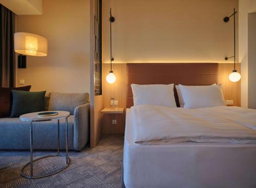 慕尼黑Adina Apartment Hotel Munich的酒店客房,配有床和沙发