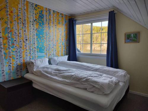 UlefossHus i Telemarkskanalens hjerte的一间卧室配有一张带窗户和窗帘的床