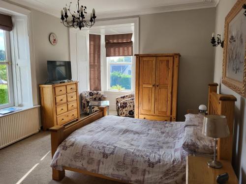 Lumphanan麦克白阿姆斯酒店的一间卧室设有一张床、一台电视和窗户。