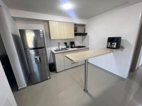贝约Hermoso Apto con Vista al Ciudad y Parqueadero Gratis的厨房配有不锈钢冰箱和木制柜台。