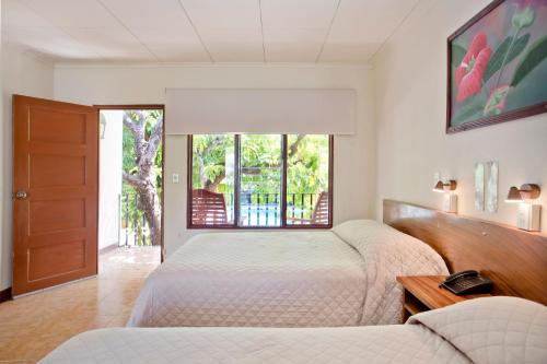 利比里亚博伊罗斯酒店的一间卧室设有两张床和窗户。