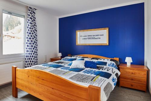 埃梅滕Elfe-Apartments FerienMietWohnungen的一间卧室配有一张蓝色墙壁的床