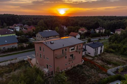 Nové JirnyLASKARA Garden Apartment by Prague Forest的享有房子的空中景色,背景是日落