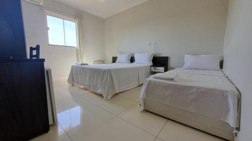 帕劳阿佩巴斯Maper Park Carajás的白色的客房设有两张床和窗户。