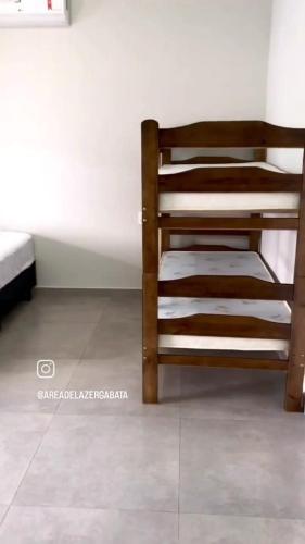 德尔菲诺波利斯Área de laser Gabata的铺有瓷砖地板的客房内的一张木制双层床