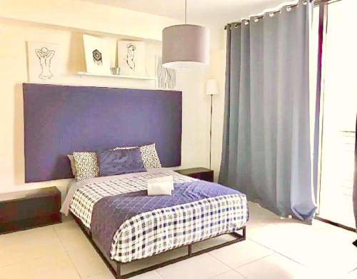 迈阿密Doral Skyline 2B的一间卧室配有一张带紫色床头板的床