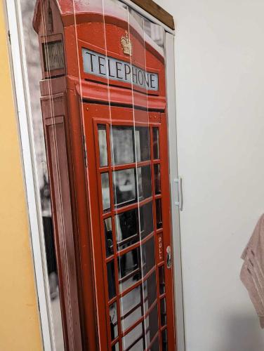 海乌姆诺OneRoom的红色的电话亭坐在房间里