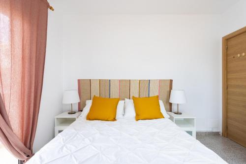 格拉纳迪利亚德亚沃纳EDEN RENTALS 102 Surfy Stylish Bed&Coffee Balcony的一间卧室配有白色床和黄色枕头