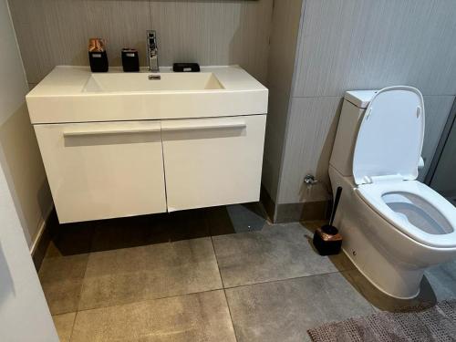 阿克拉Beaufort Ridge 402的浴室配有白色水槽和卫生间。