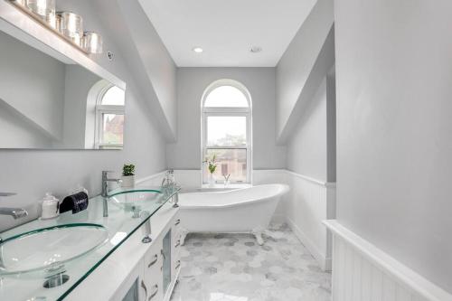 底特律The Lumber Baron's Penthouse 3BR / 2.5 BA的白色的浴室设有浴缸和水槽。