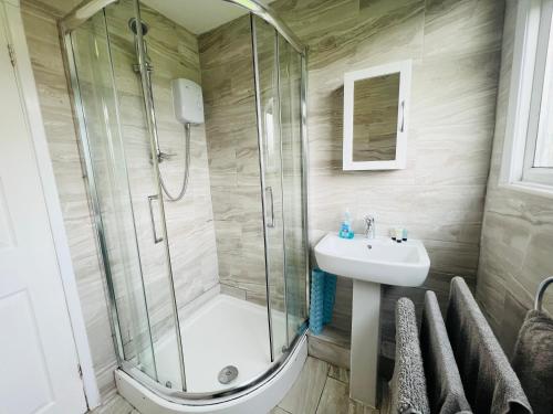 桑当2 Bedroom Chalet SB22, Sandown Bay, Isle of Wight, Dog Friendly的带淋浴和盥洗盆的浴室