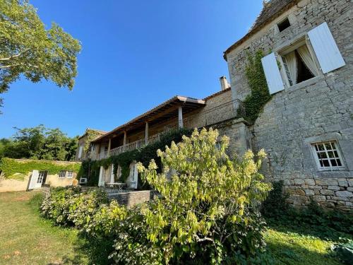 DuravelChâteau la Gineste - Castle and Vineyard的一座古老的石头建筑,前面有灌木丛