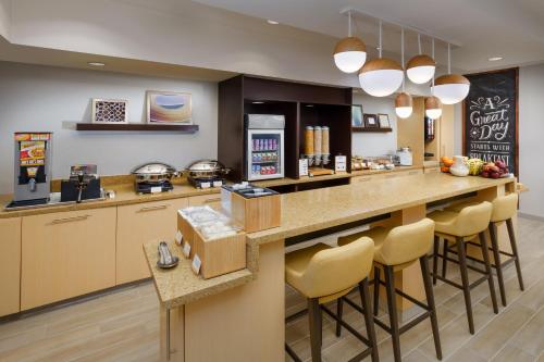 曼切斯特曼切斯特波士顿地区机场广场套房酒店的厨房配有吧台凳
