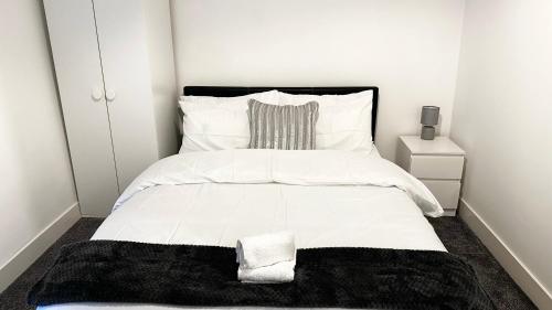 谢菲尔德Comfortable Modern Bedroom Space with Ensuite near Bramall Lane Stadium and RHH的卧室配有一张带黑色毯子的白色床