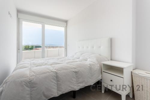 卡耐特蒂贝兰格Apartamento de lujo con 2 habitaciones en Canet d'en Berenguer的白色的卧室设有床和窗户
