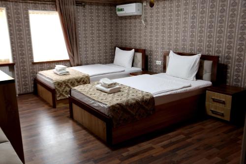 撒马尔罕Hotel Plaza 777的酒店客房设有两张床和窗户。