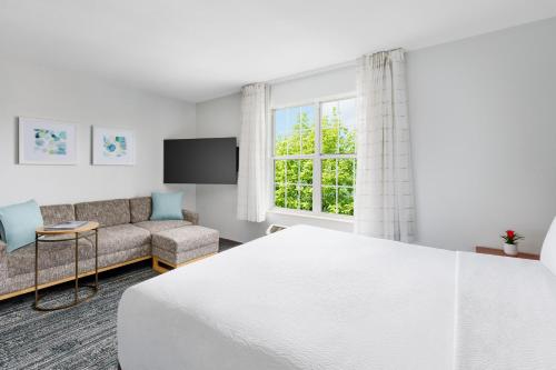 霍舍姆费城霍舍姆广场套房酒店的一间卧室配有一张床、一张沙发和一个窗口