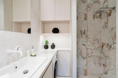 海若克利欧Euphoria Luxury Apartment的带淋浴和盥洗盆的白色浴室