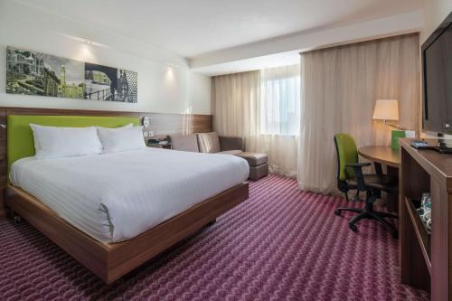 伯明翰希尔顿伯明翰大街汉普顿酒店的酒店客房设有一张大床和一张书桌。
