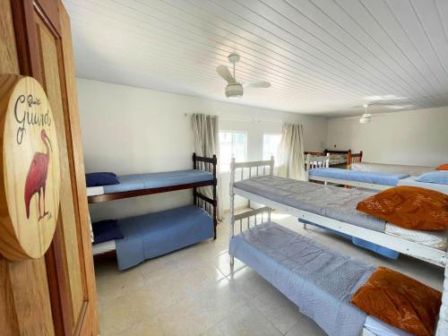 瓜拉派瑞Casa Amarela Hostel的一间设有四张双层床和天花板的客房