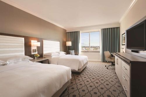 圣盖博洛杉矶/圣加布里埃尔希尔顿酒店的酒店客房设有两张床和一台平面电视。