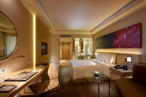 吉隆坡吉隆坡希尔顿逸林酒店的酒店客房设有一张大床和一张书桌。