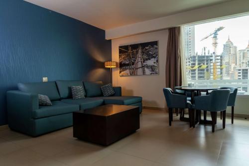 巴拿马城巴拿马城汉普顿希尔顿酒店的客厅配有蓝色的沙发和桌子