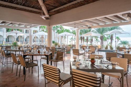 圣何塞德尔卡沃Hilton Los Cabos的一间带桌椅和遮阳伞的餐厅