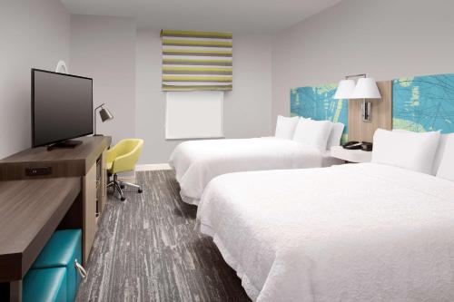 迈阿密迈阿​​密机场伊斯特汉普顿酒店的酒店客房设有两张床和一台平面电视。