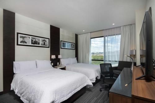 圣路易斯波托西Hampton Inn By Hilton San Luis Potosi的酒店客房设有两张床和一台平面电视。