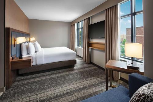 南本德Embassy Suites by Hilton South Bend的酒店客房设有一张床和一个大窗户