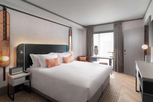伦敦Hart Shoreditch Hotel London, Curio Collection by Hilton的酒店客房设有一张白色大床和一张书桌
