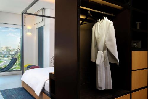 迪拜Canopy by Hilton Dubai Al Seef的一间卧室配有一张床和镜子