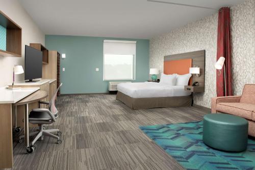 哥伦布Home2 Suites By Hilton Columbus Polaris的酒店客房,配有一张床、一张桌子和椅子