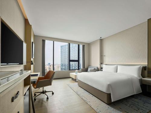 成都成都滨江希尔顿逸林酒店的酒店客房设有一张大床和一张书桌。
