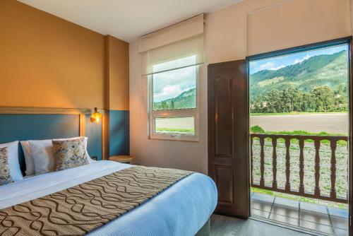 卡希卡Hotel Xue Sabana的一间卧室设有一张床和一个大窗户