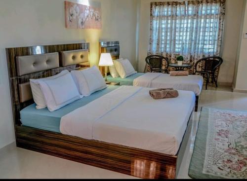 士姑来Arfaan Guest House的一间卧室配有两张床和一张桌椅