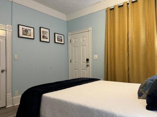 坦帕Luxury Suite by Tampa Convention Center & Hospital的卧室配有一张床,墙上挂有两张照片
