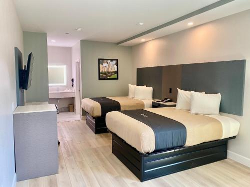 休斯顿Blue Star Inn的酒店客房设有两张床和电视。