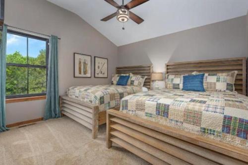 霍利斯特SPACIOUS HAPPY HOME in Branson with 8 BEDS & 6 BATHS的一间卧室配有两张床和吊扇